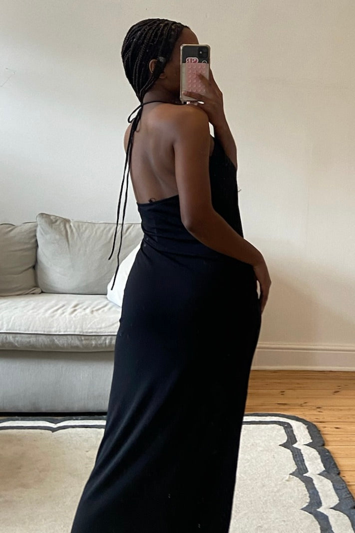Black dress featuring V-neckline, front ruching, and clean structured lines