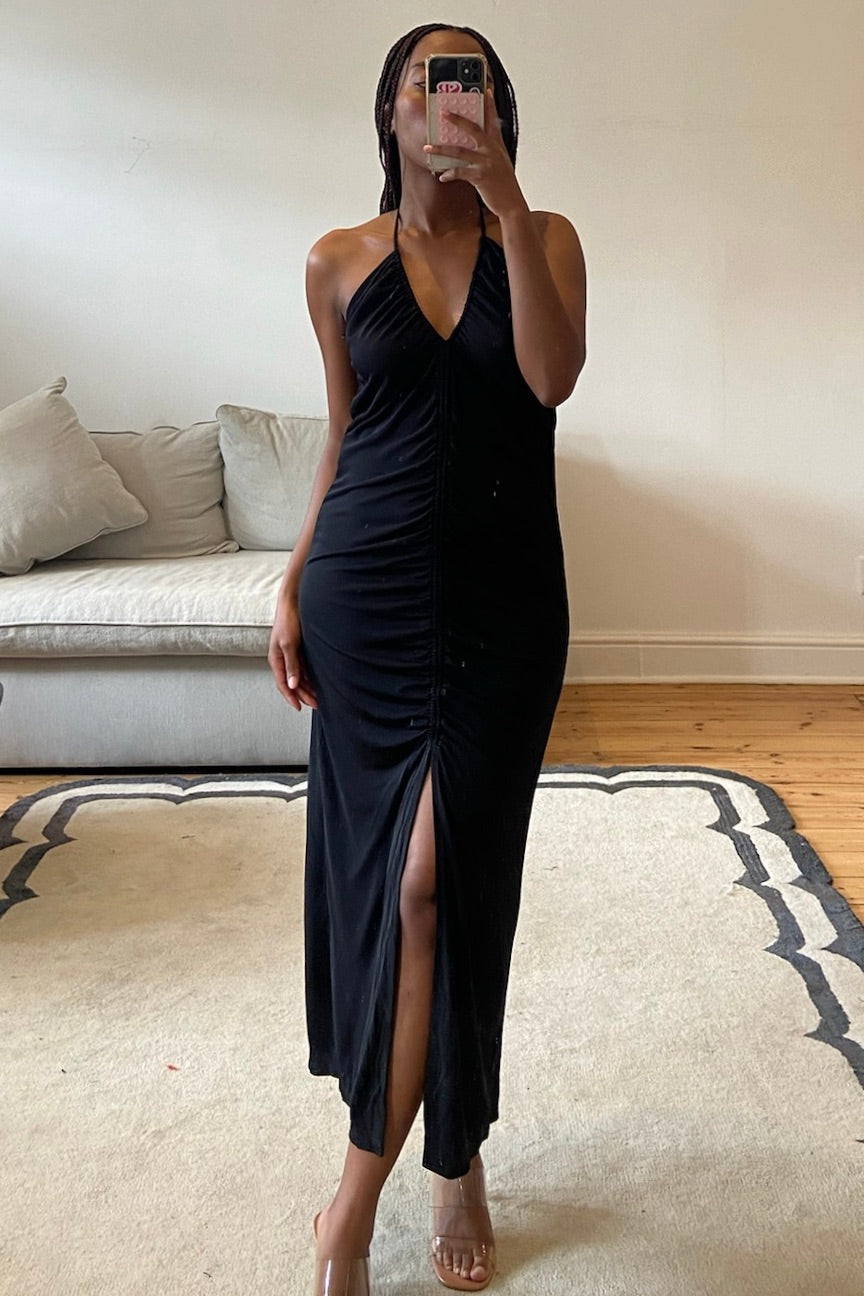 Black dress featuring V-neckline, front ruching, and clean structured lines
