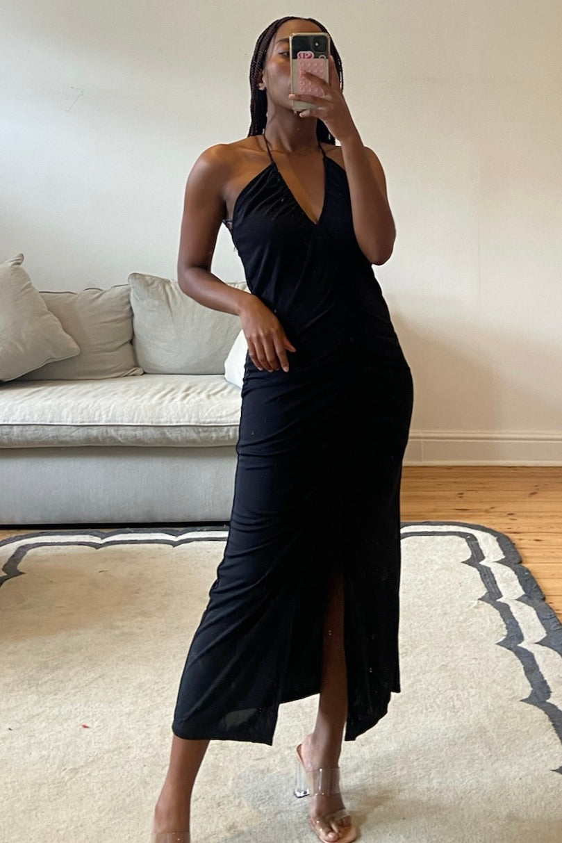 Black dress featuring V-neckline, front ruching, and clean structured lines