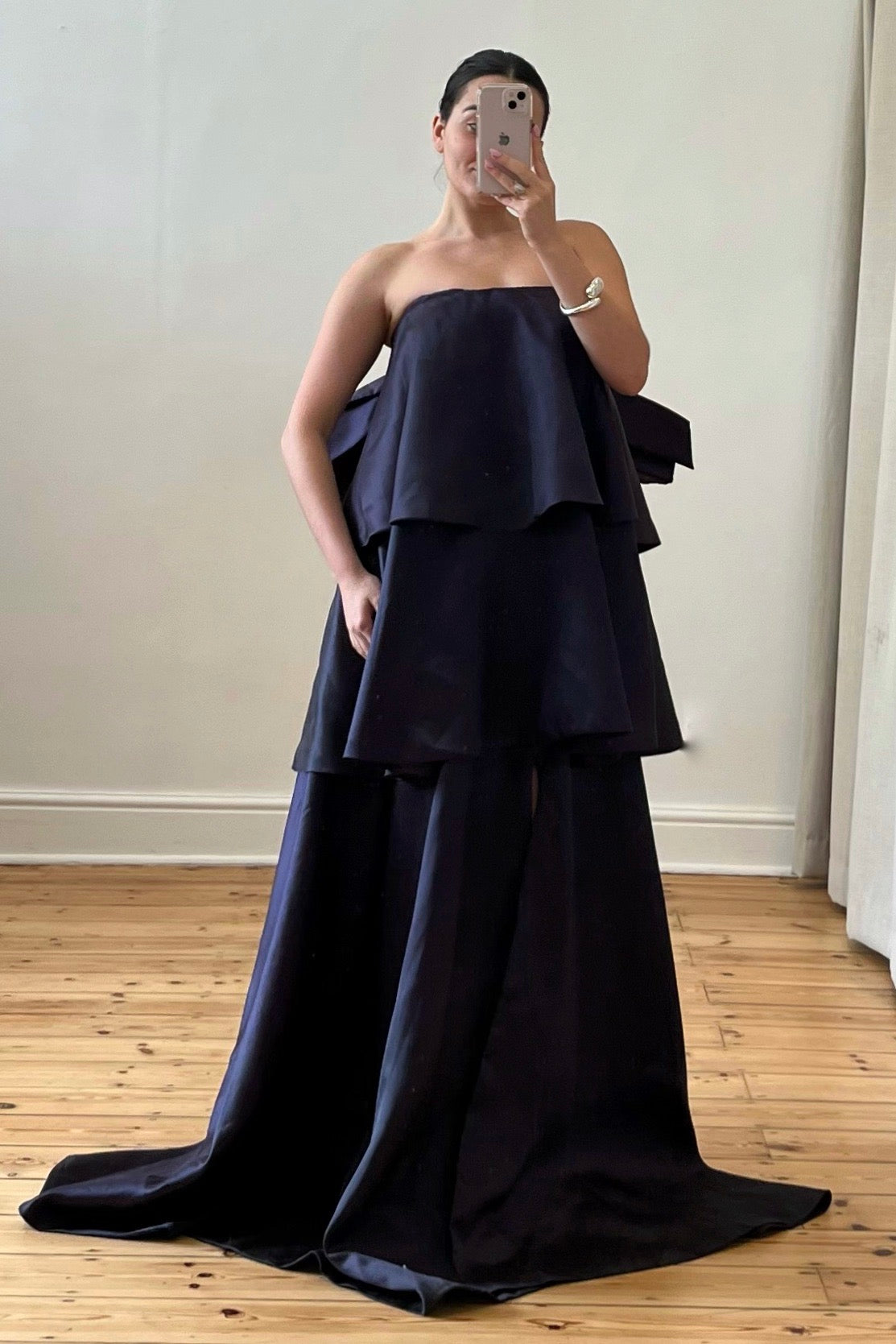 A front view of a strapless maxi gown with a full train