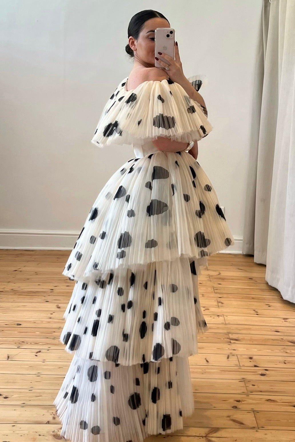 The Bradshaw Gown – a dramatic off-the-shoulder gown with micro pleats and a tiered skirt, perfect for formal occasions. Elegant, timeless, and available now.