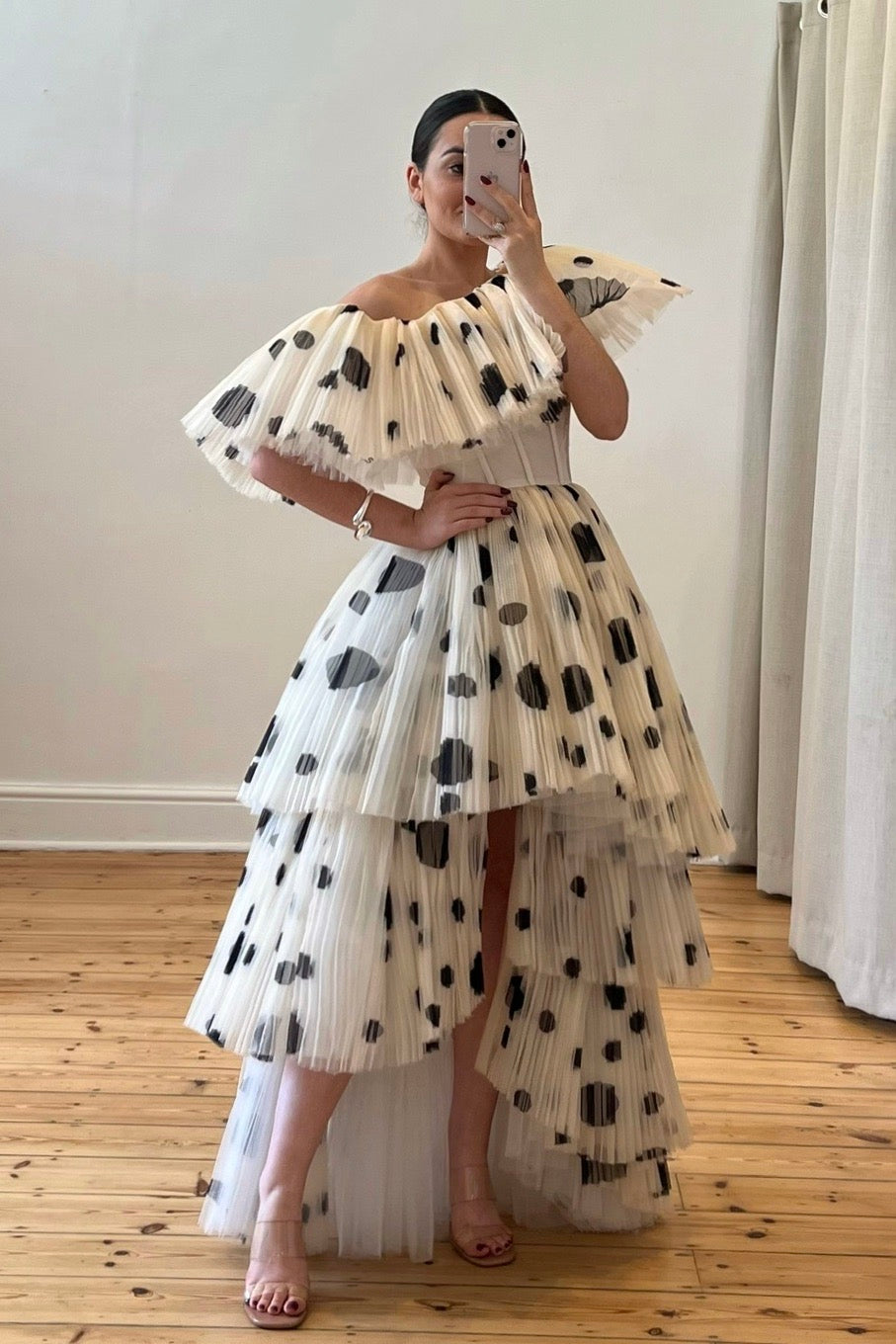 The Bradshaw Gown – a dramatic off-the-shoulder gown with micro pleats and a tiered skirt, perfect for formal occasions. Elegant, timeless, and available now.