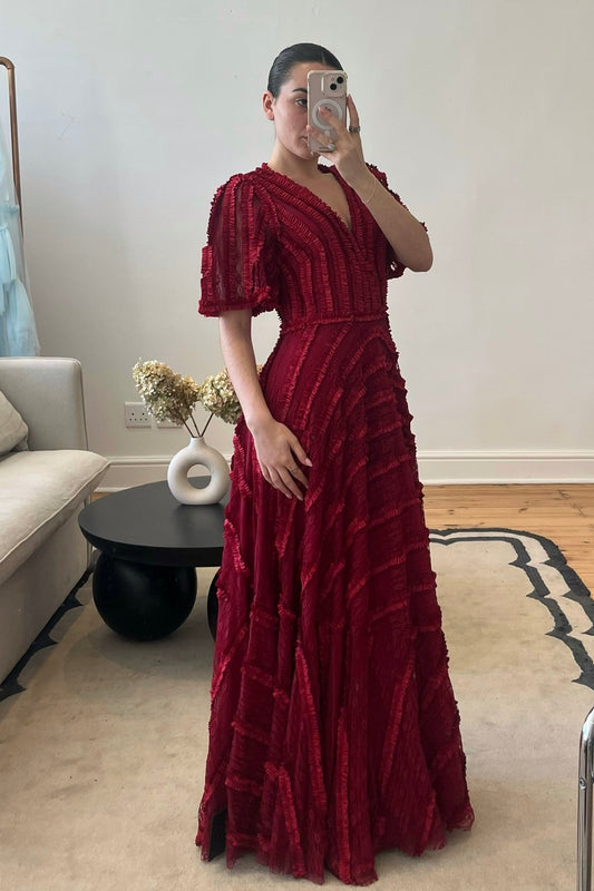 The Inae Gown by Needle & Thread – a red floor-length gown with ruffle detailing and a V-neckline, perfect for black-tie events and galas. Elegant, timeless, and available now for rental.
