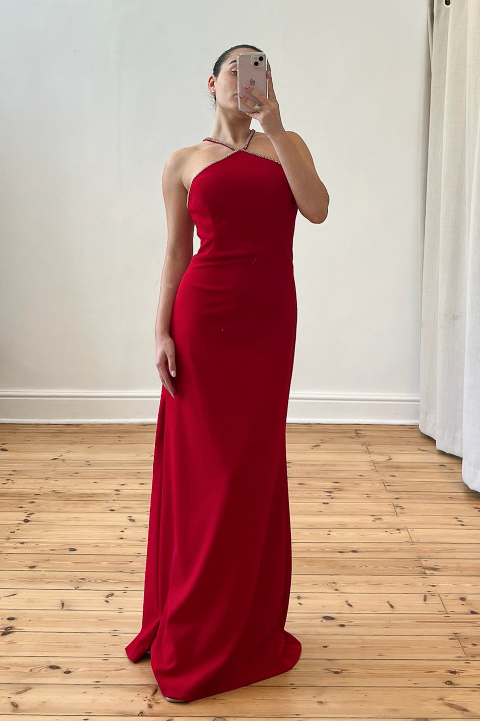 Model wearing The Mallon Gown – a red, floor-length halter neck dress with built-in cups, styled for a formal occasion. Pre-loved, size small (UK8), available on Style Rotate SResale.