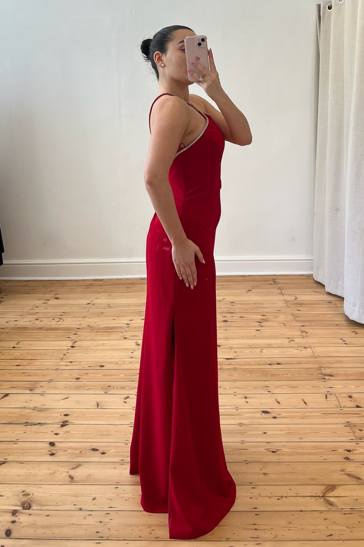 Model wearing The Mallon Gown – a red, floor-length halter neck dress with built-in cups, styled for a formal occasion. Pre-loved, size small (UK8), available on Style Rotate SResale.