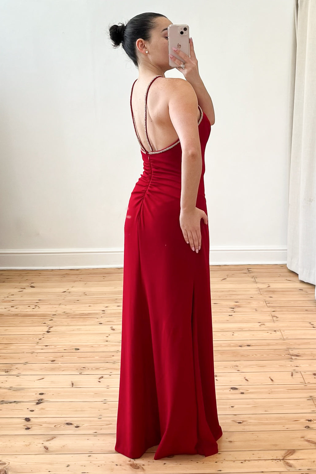 Model wearing The Mallon Gown – a red, floor-length halter neck dress with built-in cups, styled for a formal occasion. Pre-loved, size small (UK8), available on Style Rotate SResale.
