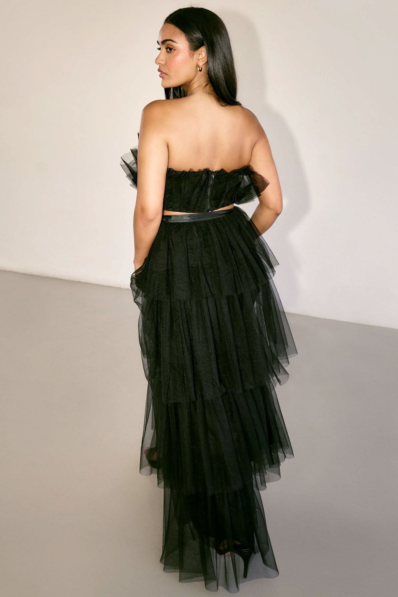 The Odessa Skirt by SR | Poetry – a tiered black tulle skirt with a sultry front slit, perfect for formal occasions. Elegant, timeless, and available now.