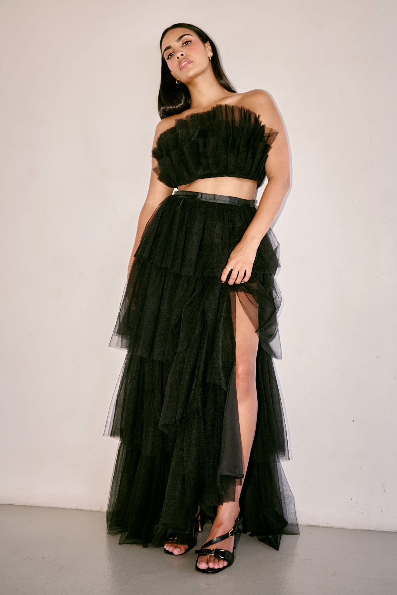 The Odessa Skirt by SR | Poetry – a tiered black tulle skirt with a sultry front slit, perfect for formal occasions. Elegant, timeless, and available now.