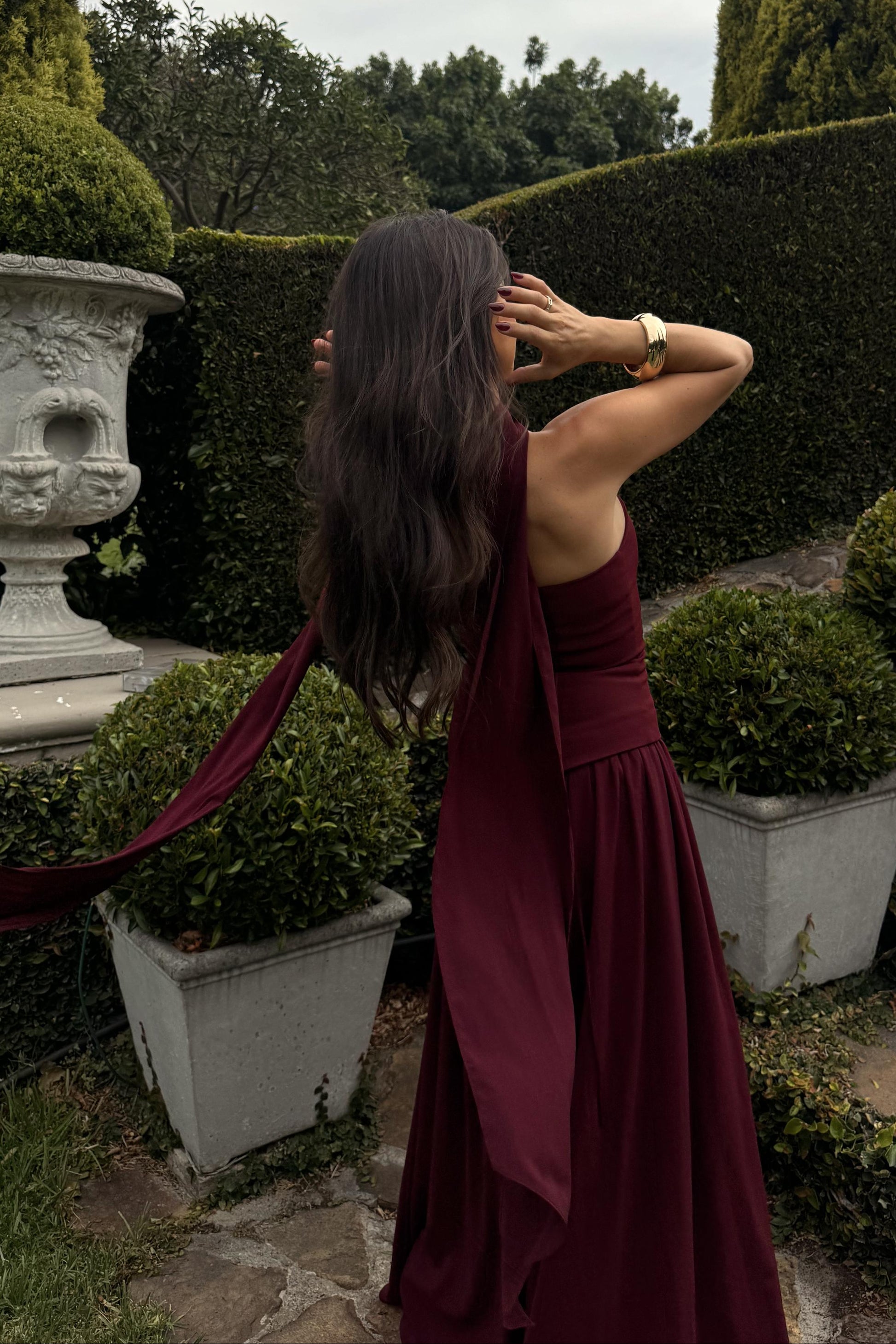 ladies formal dress back view in cherry tone with flowing full-length design