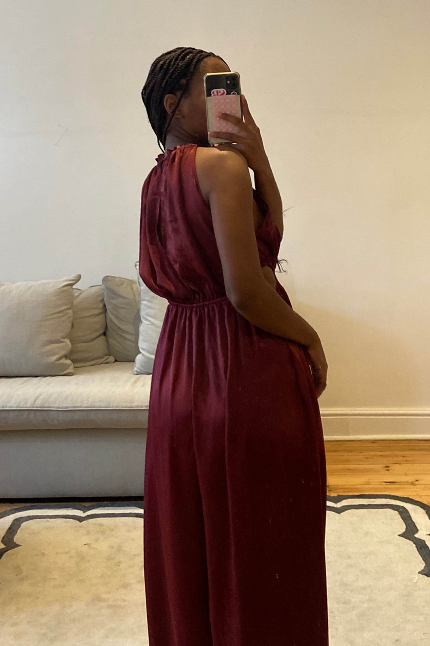 Burgundy jumpsuit with high neckline and self-tie cut-out details at the waist