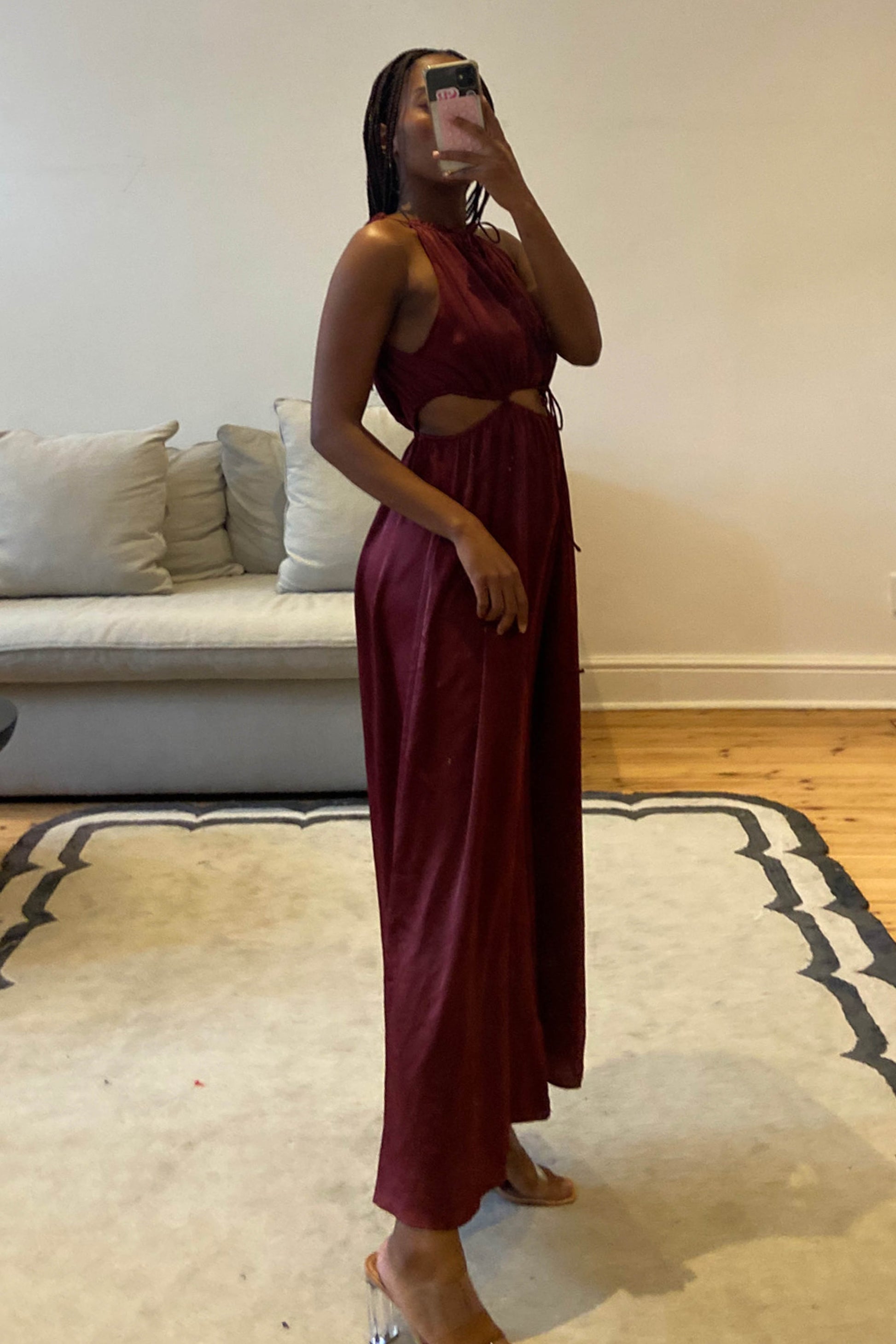 Burgundy jumpsuit with high neckline and self-tie cut-out details at the waist
